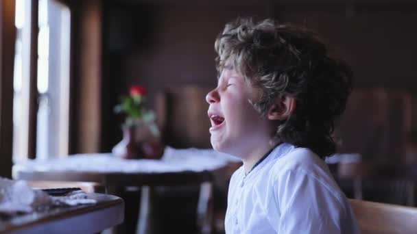 Un garçon qui pleure. Petit enfant bouleversé pleurer au café — Video