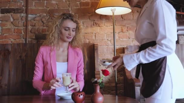 Frau im Café trinkt Kaffee mit Schokoladenbonbons — Stockvideo