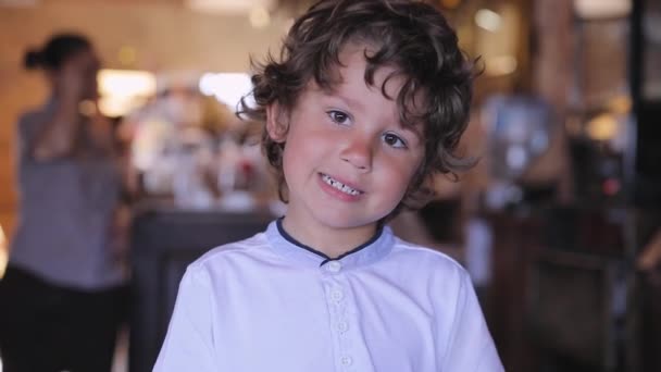 Lindo chico comer chocolate caramelo en confitería — Vídeos de Stock