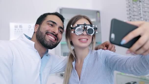 Augenzentrum. Frau macht Handy-Foto mit Arzt bei Augenuntersuchung — Stockvideo