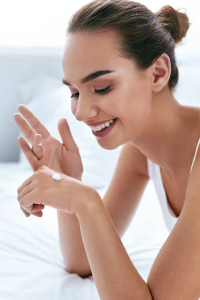 Crema de manos. Hermosa chica aplicando crema en la piel de las manos — Foto de Stock