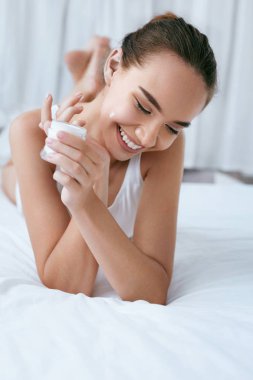 Güzellik yüz kremi. Krem cilt üzerinde uygulama güzel gülümseyen kız