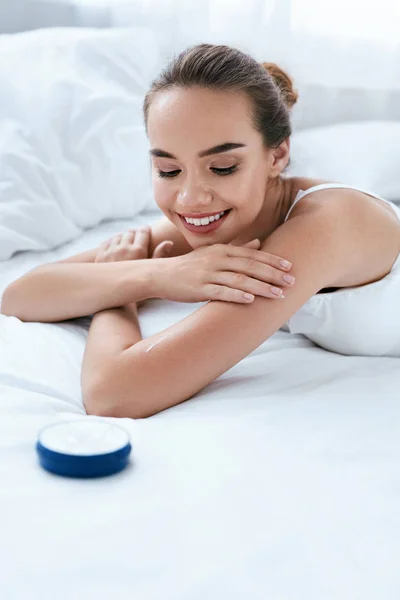 Cuidado de la piel facial. Bella mujer sonriente con crema cosmética —  Fotos de Stock