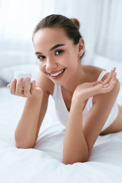 Schoonheid van de huid. Mooie vrouw met gezicht crème en gezonde huid — Stockfoto