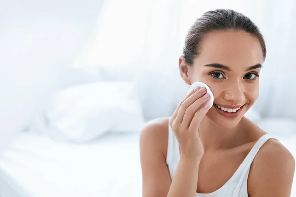 Снять макияж. Девушка очищает кожу лица с косметической прокладкой — стоковое фото