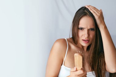 Saç dökülmesi. Fırça saçlı tutan kadın