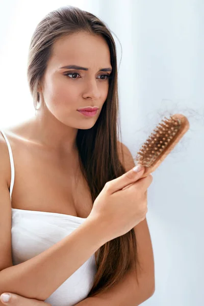 Haarausfall. Verärgerte Frau hält Bürste mit Haaren — Stockfoto