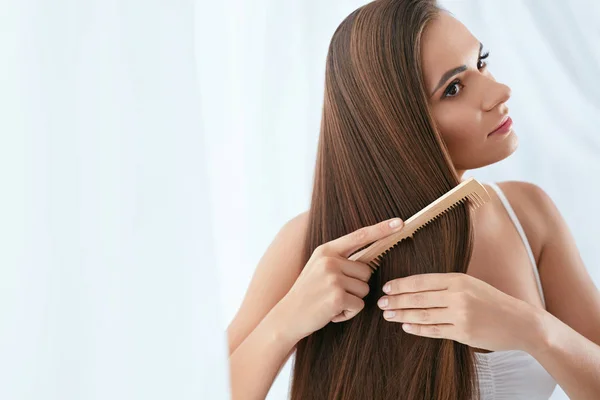 Cuidado del cabello. Mujer peinando hermoso pelo largo con cepillo de madera — Foto de Stock