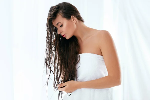 Cuidado del cabello y del cuerpo. Mujer con el pelo largo mojado envuelto en toalla — Foto de Stock