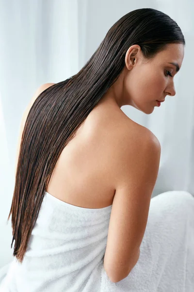 Cabelo e cuidados com o corpo. Mulher com cabelo longo molhado envolto em toalha — Fotografia de Stock