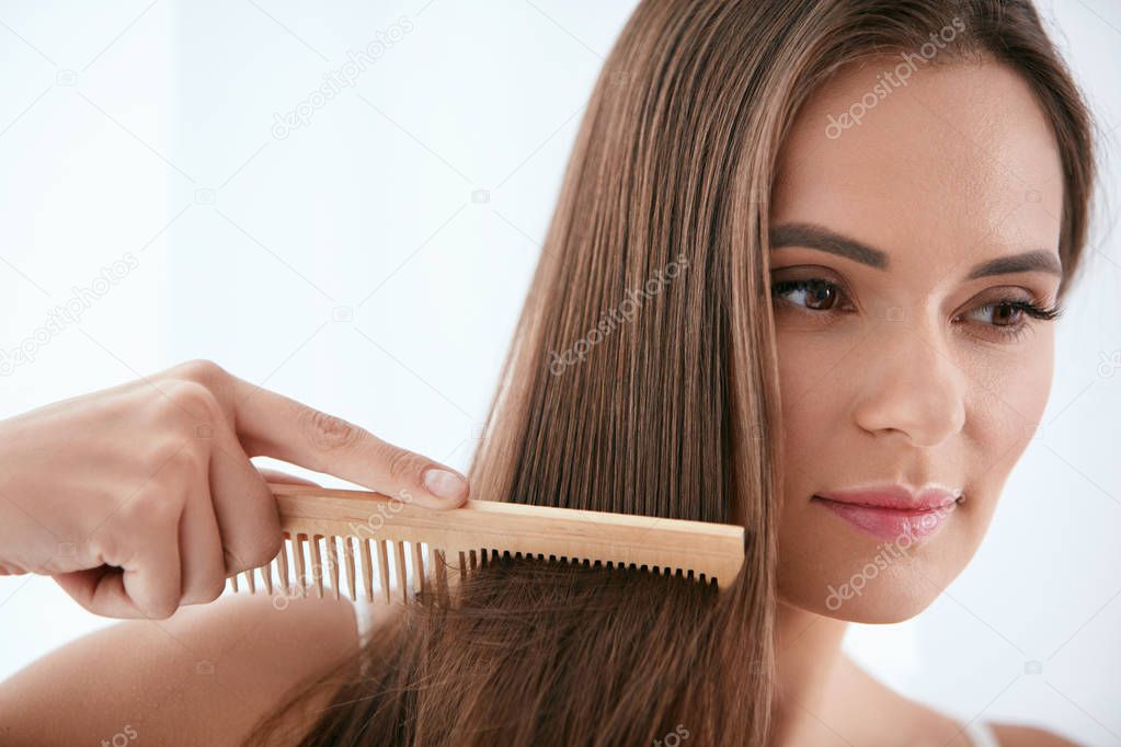 Hair Care. Woman Combing Beautiful Long Hair With Wooden Brush