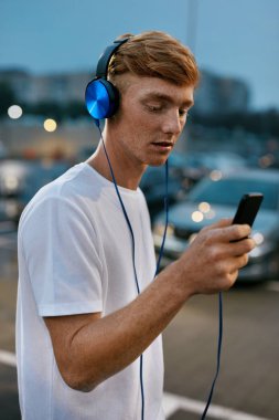 Adam cep telefonuyla şehir sokak kulaklık