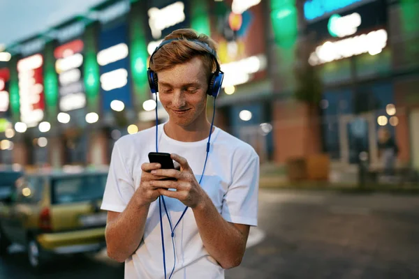 Tecnologia de pessoas. Homem ouvindo música em fones de ouvido com telefone — Fotografia de Stock