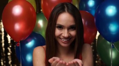 Doğum günü partisi. Gülümseyen kadın Glitter yakınındaki balon üfleme 