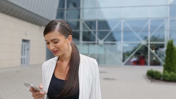 Pracovní cesty. Obchodní žena s telefonem a kufr poblíž letiště — Stock video