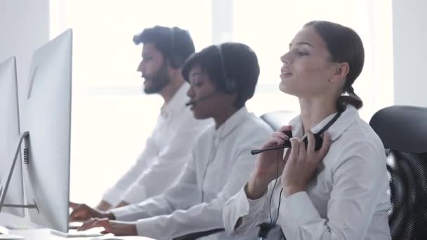 Call Center. Leende kvinna i headsetet arbetar på dator — Stockvideo