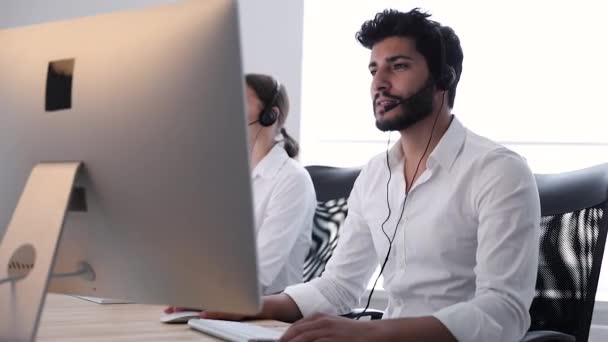联系中心代理咨询客户在线 在呼叫中心的帮助热线上工作的男人和女人 — 图库视频影像