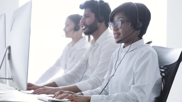 Callcenter-Betreiber. schöne schwarze Frau im Headset bei der Arbeit — Stockvideo