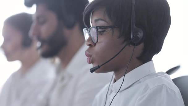 Callcenter-Betreiber. schöne schwarze Frau im Headset bei der Arbeit — Stockvideo