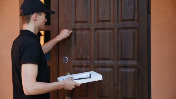 配信サービス クライアントの家 ドアの近くの食品パッケージに宅配便にピザを提供する人 — ストック動画