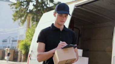 Teslimat hizmeti. Araba açık havada yakınındaki elinde kutusuyla kurye