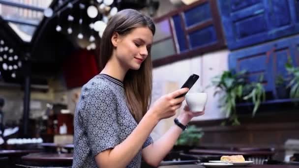 妇女与电话在咖啡厅喝咖啡 — 图库视频影像