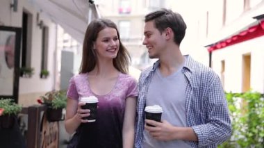 Genç insanlar içme kahve ve şehir Sokağı'nda yürüyüş