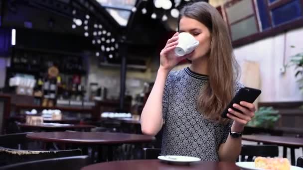 Hermosa mujer usando el teléfono en el café, beber café — Vídeos de Stock