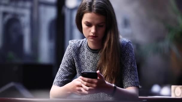 Jeune femme bouleversée avec téléphone portable au restaurant — Video