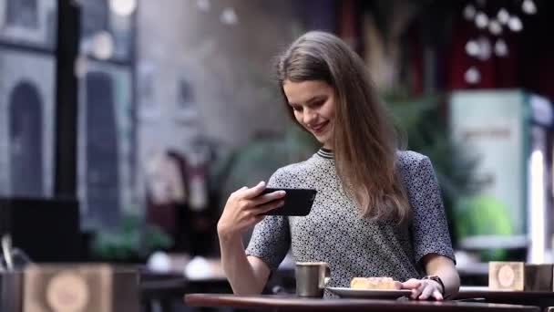 Hermosa mujer haciendo foto de comida en el teléfono móvil en el café — Vídeos de Stock