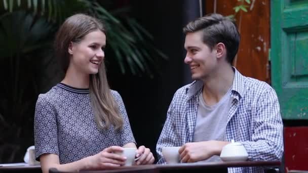 Paar im Café. Jugendliche trinken Kaffee und kommunizieren — Stockvideo