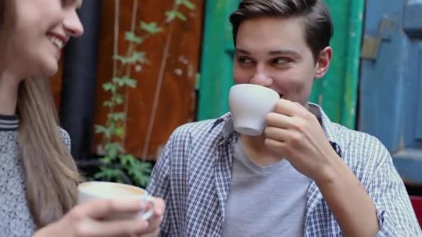 Hombre joven bebiendo café con la mujer en el café — Vídeos de Stock
