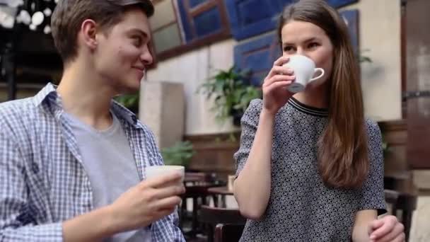 Пара в кафе. Молодые люди пьют кофе и общаются — стоковое видео