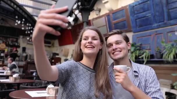 Pareja haciendo foto en el teléfono móvil en la cafetería — Vídeos de Stock