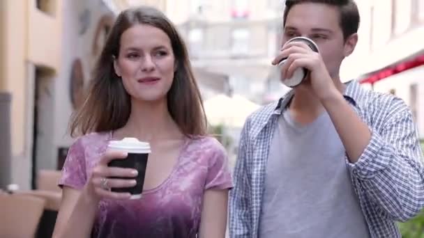 Νέοι άνθρωποι πίνουν καφέ και το περπάτημα στο δρόμο της πόλης — Αρχείο Βίντεο