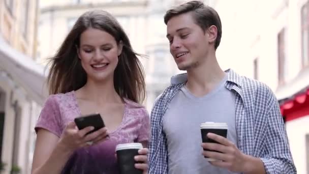 Lyckliga par med mobiltelefon och dricka kaffe utomhus — Stockvideo