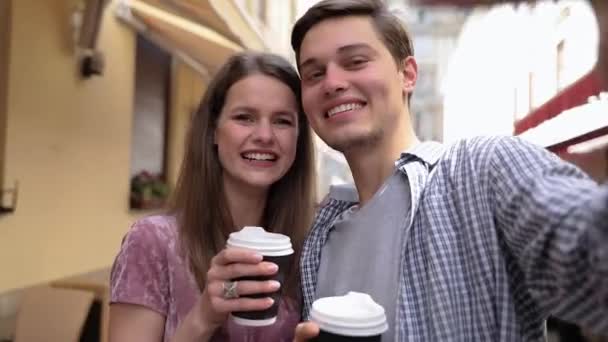 Pareja haciendo foto por teléfono y bebiendo café en la calle — Vídeos de Stock