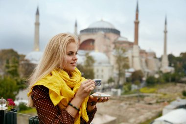Arka plan üzerinde cami ile Türk kahvesi içme kadın
