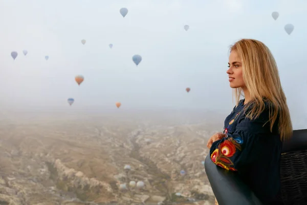 Viajar. Mulher bonita voando no balão de ar quente no céu — Fotografia de Stock