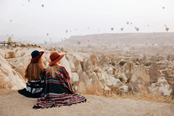 Les gens voyagent. Femmes en chapeaux sur la colline jouissant de ballons volants — Photo