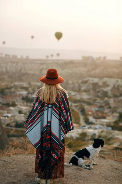 女性が熱気球で空と丘の上の犬と旅行 — ストック写真