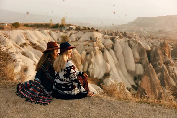 Подорожі. Жінки дивляться на літаючі гарячі повітряні кулі в небі — стокове фото