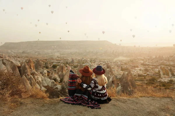 Les gens voyagent. Femmes en chapeaux sur la colline jouissant de ballons volants — Photo
