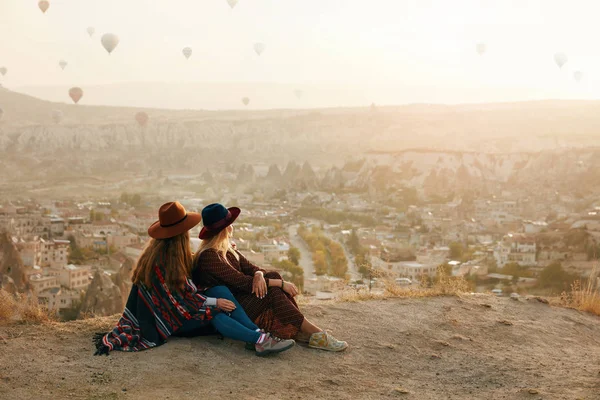 Ταξίδια άτομα. Γυναίκες σε καπέλα πάνω σε λόφο, απολαμβάνοντας πέταγμα αερόστατων — Φωτογραφία Αρχείου