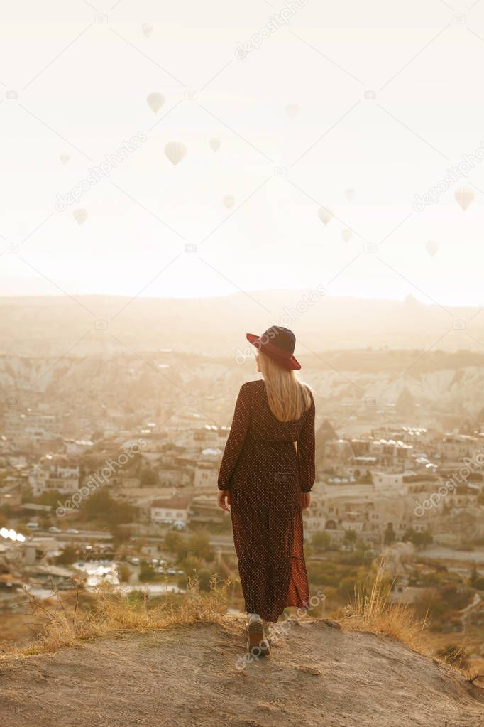 Travel. Beautiful Woman In Hat With Flying Air Balloons In Sky