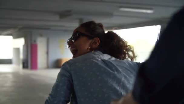 Улыбающаяся женщина развлекается в корзине для покупок на парковке — стоковое видео