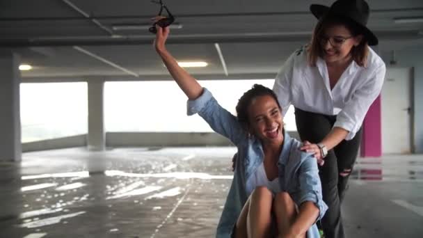 Souriant Femmes Skateboard et avoir du plaisir au parking — Video