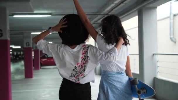Schöne junge Frauen haben Spaß auf dem Parkplatz — Stockvideo