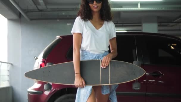 Sorridente bella donna in abiti casual con skateboard — Video Stock