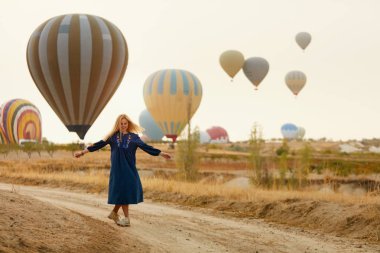 Kadın sıcak hava balonları arka plan üzerinde uçan ile eğleniyor